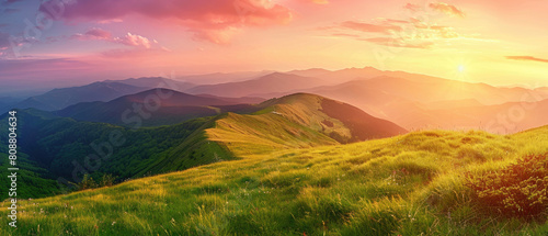Beautiful nature summer scene with green grass on mountains hills and sunset cloudy sky over mountains as background looking at wide angle lens
