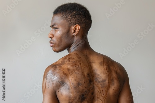 black man with bare back on grey background, sweat running down face and naked dirty back, authentic image
