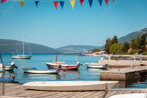 Beautiful sunny view of village pier with boats on the Mediterranean coast. Summer vacation at resort