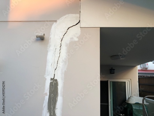 Cracked building concrete wall at the outside reveals clear fissures due to soil subsidence. This 8 year old house's photo was taken on October 26, 2023.