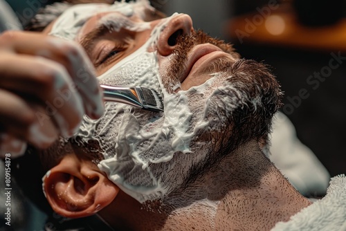 A man is carefully shaving his face with a razor blade, A barber using hot towels and straight razors for a luxurious shave experience