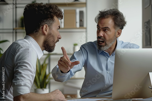 Angry boss criticizing scolding sad male employee for computer mistake incompetence at workplace, mad leader reprimanding rebuking shouting at subordinate lazy worker blaming of bad work in office 