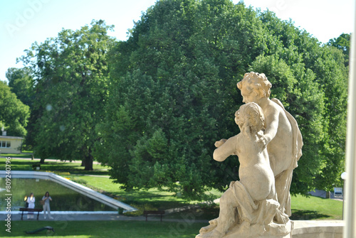 zdjęcie rzeźby przedstawiających dwóch przytulonych młodzieńców z zielonym parkiem w tle