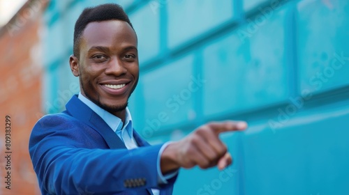 Smiling man in blue attire pointing ahead