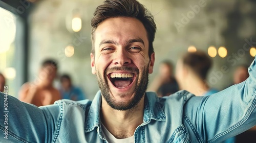 Portrait of a young man laughing while taking a selfie in a cafe