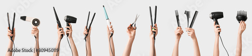 Many hands with hairdresser's supplies on grey background