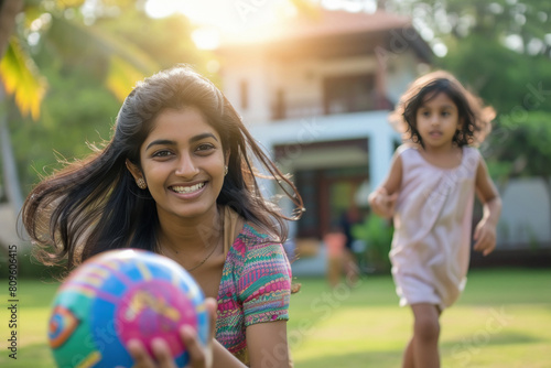 Indian mother playing ball with her daughter at home garden