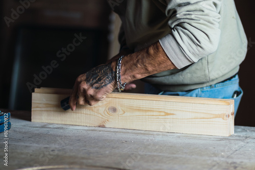 Hands carpenter touching wooden dowel