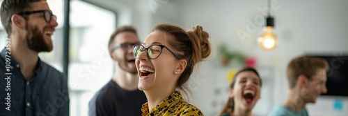 A cheerful young woman laughing heartily with colleagues, promoting a positive and fun office culture