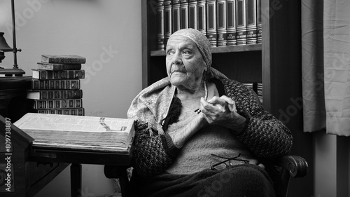 Foto scattata ad una nonna con a fianco una raccolta di libri antichi.
