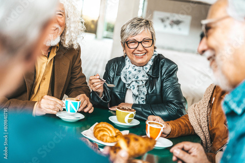 Happy senior people having breakfast sitting at cafe bar - Group of older friends having lunch in terrace restaurant - Food and beverage life style concept