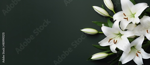 A top down view of a condolence card featuring white lilies with ample blank space for images