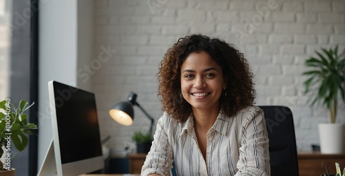  Modern day worker, Portrait of happy biracial business woman freelancer sit by computer at comfy workplace at corporate workspace or at home, Smiling young indian lady office employee look at camera