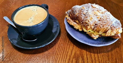 Cup of delicious aromatic coffee and bun with nuts for breakfast