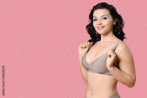 Beautiful young happy body positive woman in stylish underwear on pink background