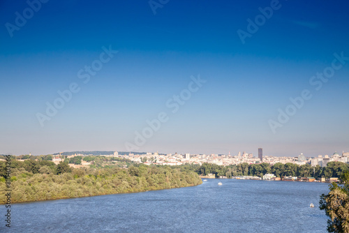 Aerial panorama of Belgrade, serbia, seen from afar, above the reka sava river in summer with blue sky and boats passing. Belgrade is the capital city of Serbia.