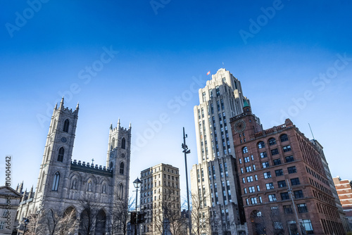 Notre Dame Basilica in the Old Montreal and its iconic towers, with the Aldred Building in backgground. The basilica is the main cathedral of Montreal, and a touristic landmark.