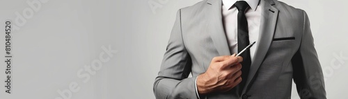 Produce an image of a male business leader in a charcoal grey suit, showing torso, with one hand on the other arm