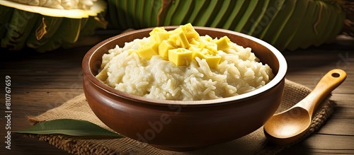 A delicious and creamy combination of sticky rice and durian cooked in coconut milk and presented in a bowl on a wooden table The image provides copy space for recipes articles or commercial use