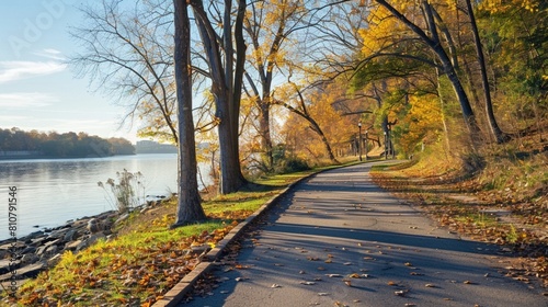 A pedestrian and bike trail along Potomac River in Arlington, VA, USA. Trail among deciduous trees on a sunny morning in autumn.