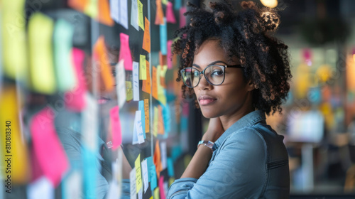 Young woman contemplating ideas on a sticky note board