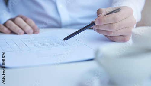 Hand, medical paperwork and pen at desk for information, report or history with planning for wellness. Person, documents and writing with checklist, decision and legal contract for health in hospital