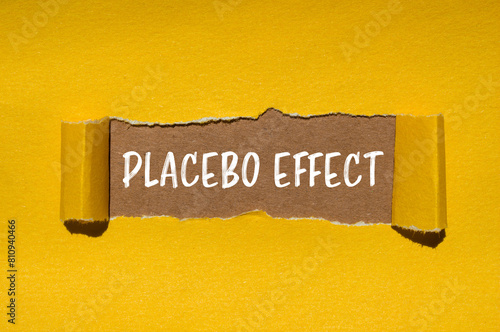 Placebo effect words written on ripped yellow paper with brown background. Conceptual placebo effect symbol. Copy space.