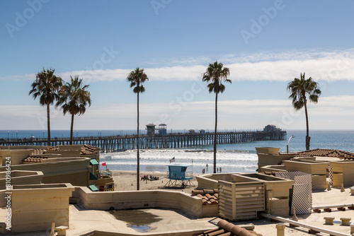a scenic view over the beautiful coastline of oceanside with beautiful residential buildings and palm trees at a sunny day, california
