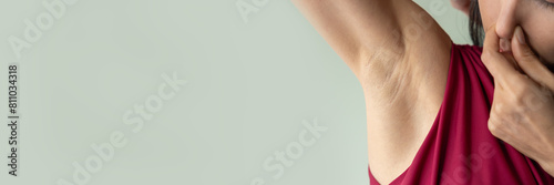 Young Asian woman sweating, feeling bad and uncomfortable with stinking smelly odor or bad musty smell during summer day with high temperature or heat wave, healthcare and body care concept image