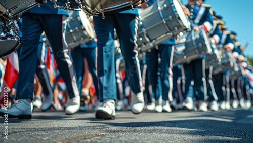  Low-angle view of a marching band parade focusing on drummers and flag bearers in uniform, evoking a sense of patriotic celebration.