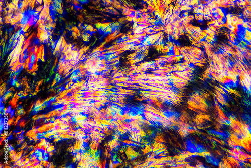 Extreme macro photograph of Meloxicam crystals forming vibrant abstract modern art patterns, when illuminated with polarized light, under a microscope objective with 50x magnification