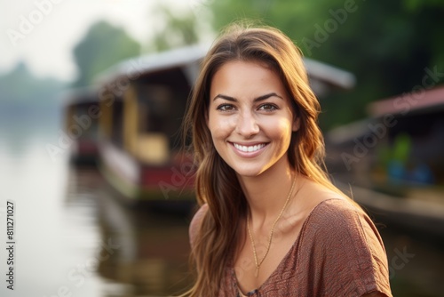 A Serene Close-Up Portrait of a Smiling Young Woman with a Charming Houseboat Moored Along a Tranquil River in the Background