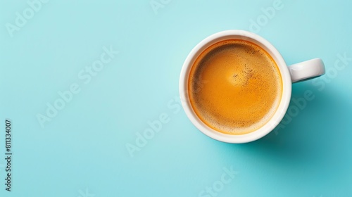 Freshly brewed coffee in a white cup on a blue background. Top view.
