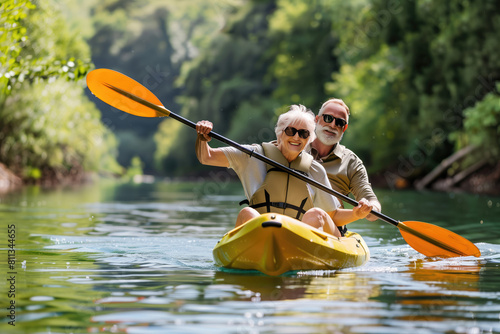 Senior couple kayaking on the river. Healthy elders enjoying summer day outdoors. Sportive people having fun at the nature. Active retirement concept