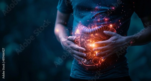 Stomach pain, indigestion concept with man holding his belly and glowing illustration of healthy anatomy organ on dark background.