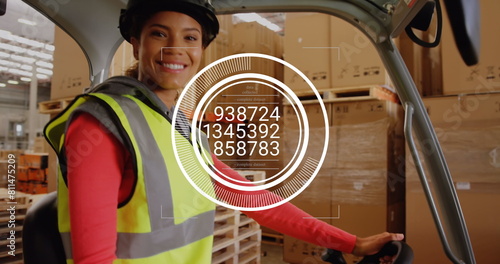 Image of changing numbers in circles over smiling biracial woman driving forklift in warehouse
