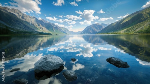 Scenic mountain lake in summer morning Altai Stunning mirror image of mountains sky and white clouds Transparent water rocks at the lake bed