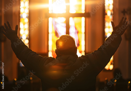 backlit image of a believer hands to heaven worshiping the cross