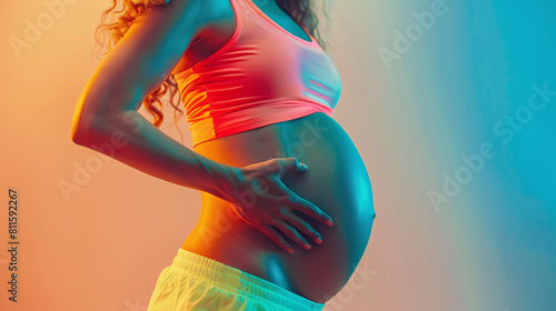 Young pregnant African American woman posing against plain background