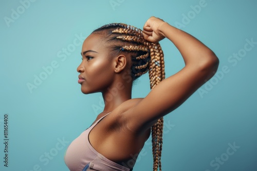 A young woman with two braids flexing her biceps in a side profile, exuding strength and confidence