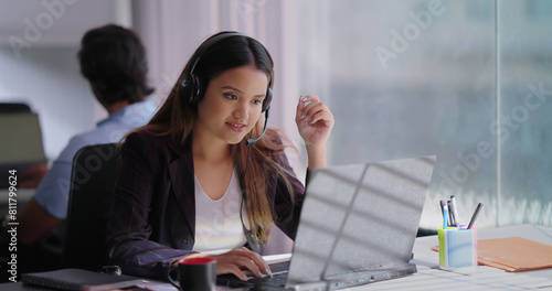 Indian Asian Hindu busy gen z lady woman sitting chair use laptop talk speak client online video call indoor office young adult cute female girl staff worker agent do sales task job centre look screen