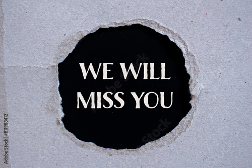 We will miss you words written on ripped paper with black background. Conceptual we will miss you symbol. Copy space.