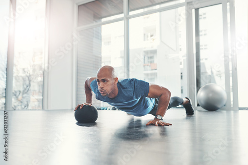 Workout, man and push up in gym for fitness, health and wellness, athlete and training. Exercise, strong and bodybuilder in sport club for body endurance, performance and medicine ball for muscle