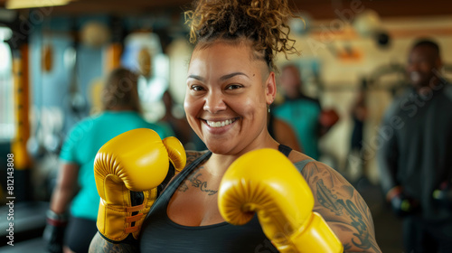 A confident woman boxer at a gym, with a smile, flaunting her yellow gloves.