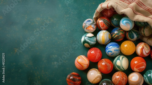 Colorful marbles scattered on textured green surface with piece of cloth