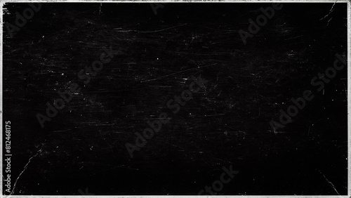 A close-up view of a black paper cover surface textured with dust and scratches