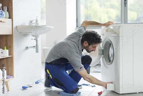 Plumber repairing a clogged washing machine