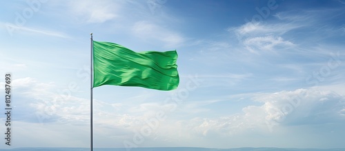 A close up view of a green flag against a scenic sky background providing ample copy space for additional content