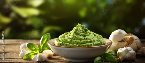 A tasteful bowl of pesto sauce and ingredients arranged on a wooden background creating a visually appealing composition with copy space image