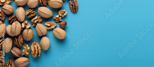 Top view of scattered halves of pulp and whole walnut on a blue background creating a visually pleasing copy space image